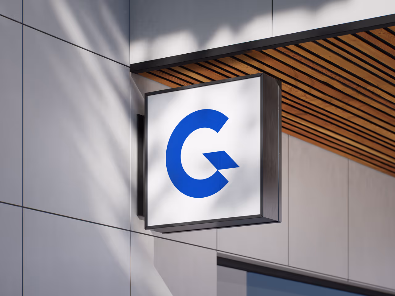 Sygnet Genius Flow na białym tle zamontowany na rogu budynku z jasnoszarymi panelami i drewnianym sufitem.