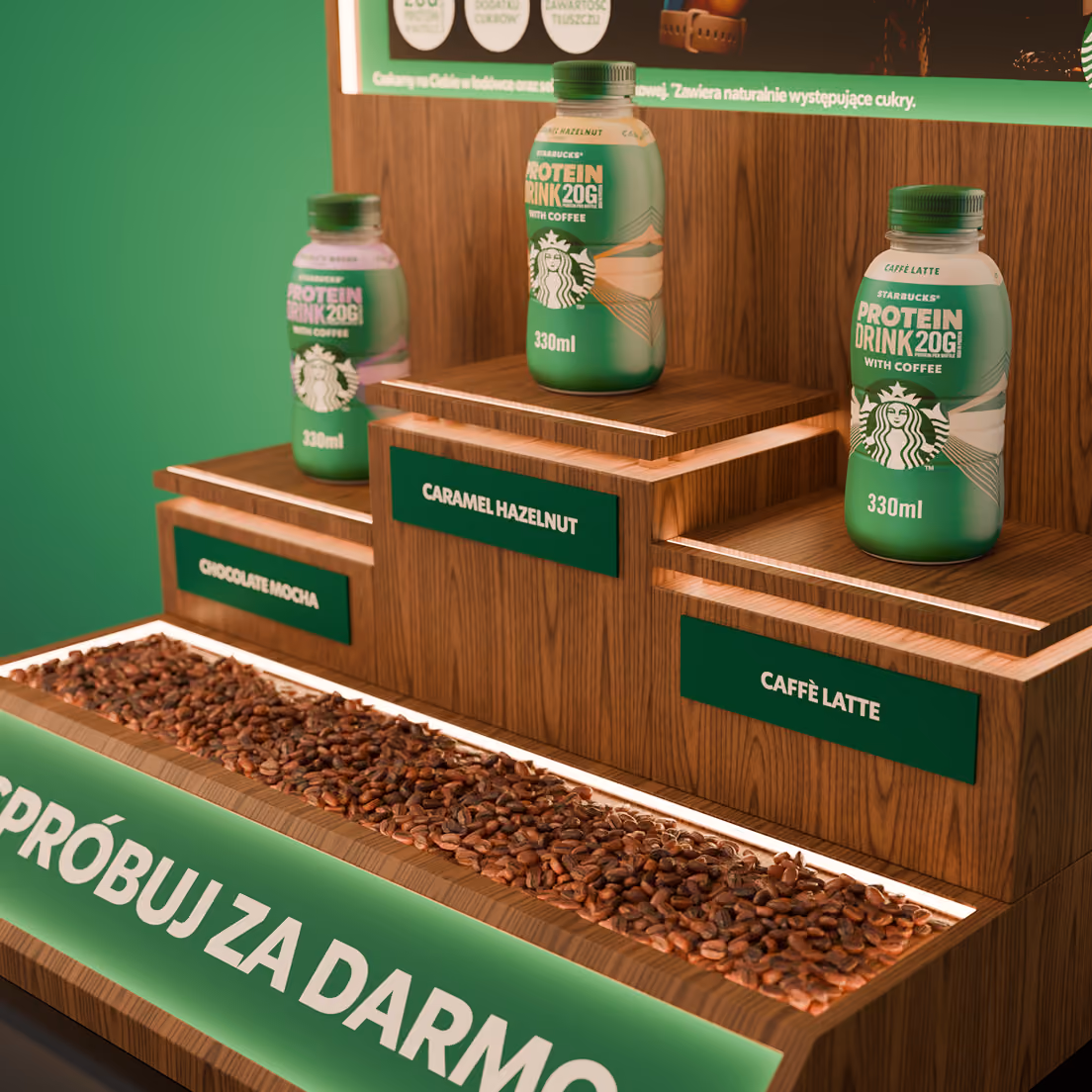 Trzy butelki Starbucks Protein Drink 330 ml: Chocolate Mocha, Caramel Hazelnut, Caffè Latte na drewnianych półkach.