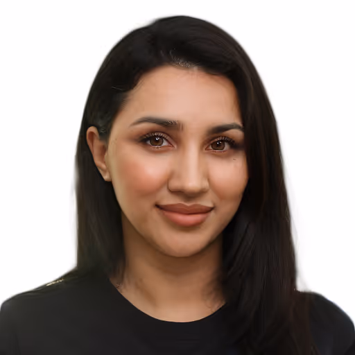 Porträt einer lächelnden Frau mit langen schwarzen Haaren vor weißem Hintergrund.