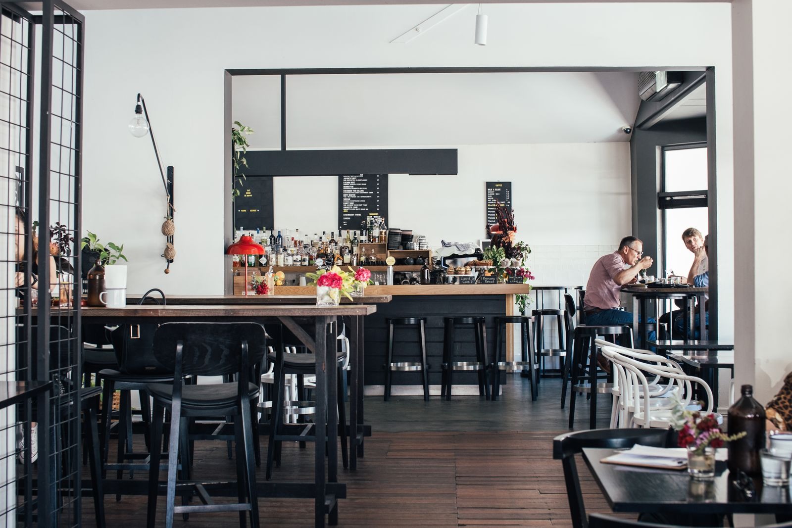 Modernes Café im Einzelhandel als sozialer Treffpunkt mit Gästen an Tischen