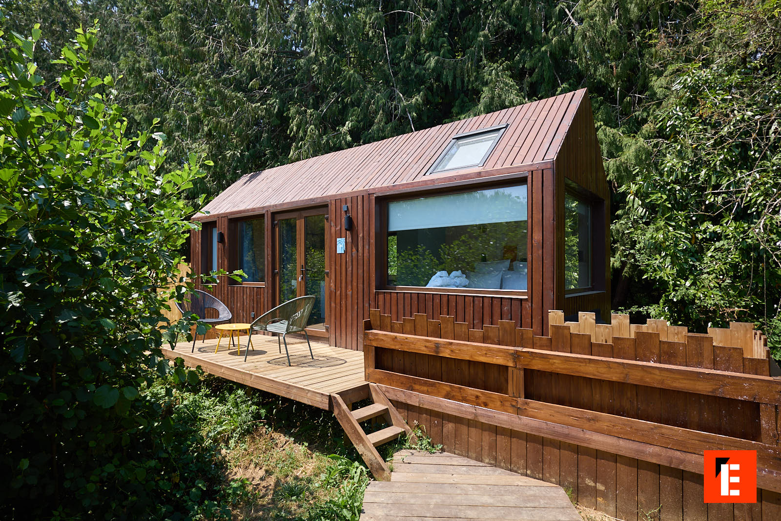 Lodge PAMPA Azur en bois avec sa terrasse et sa fenêtre de toit, en pleine journée sur le domaine d'Étival-lès-le-Mans