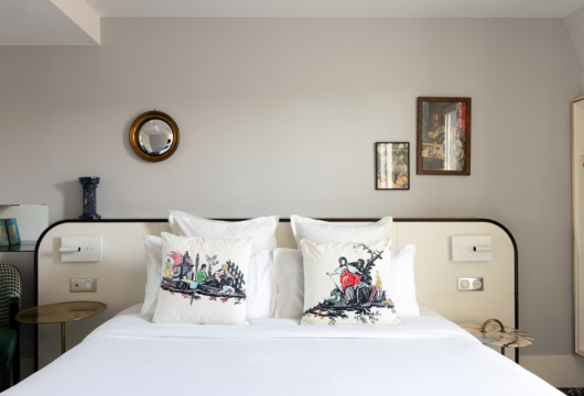 Chambre avec lit deux places et motifs sur les coussins Machefert Group