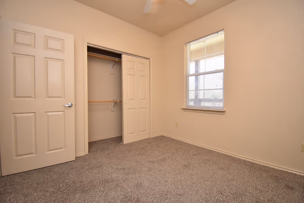 Empty bedroom with open closet door