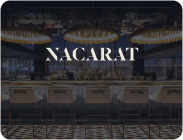 Stylish bar interior with modern stools and large circular ceiling lights, branded with 'NACARAT' text overlay.