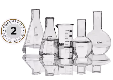 Variety of empty laboratory glassware including beakers and flasks of different shapes and sizes reflecting on a surface.