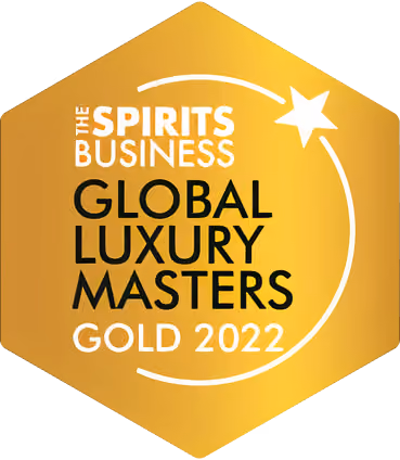 Gold hexagonal emblem with text: The Spirits Business Global Luxury Masters Gold 2022, featuring a white star and curved line design.