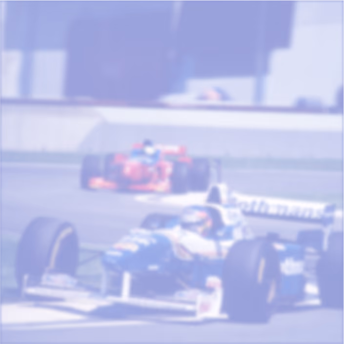 Two Formula 1 race cars on a racetrack, with a blue and white car in the foreground and a red car in the background.
