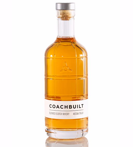 Clear glass bottle of Coachbuilt blended Scotch whisky with amber liquid and a white label.