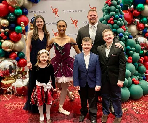 Image of Adam's family enjoying a ballet/opera during Christmas time.