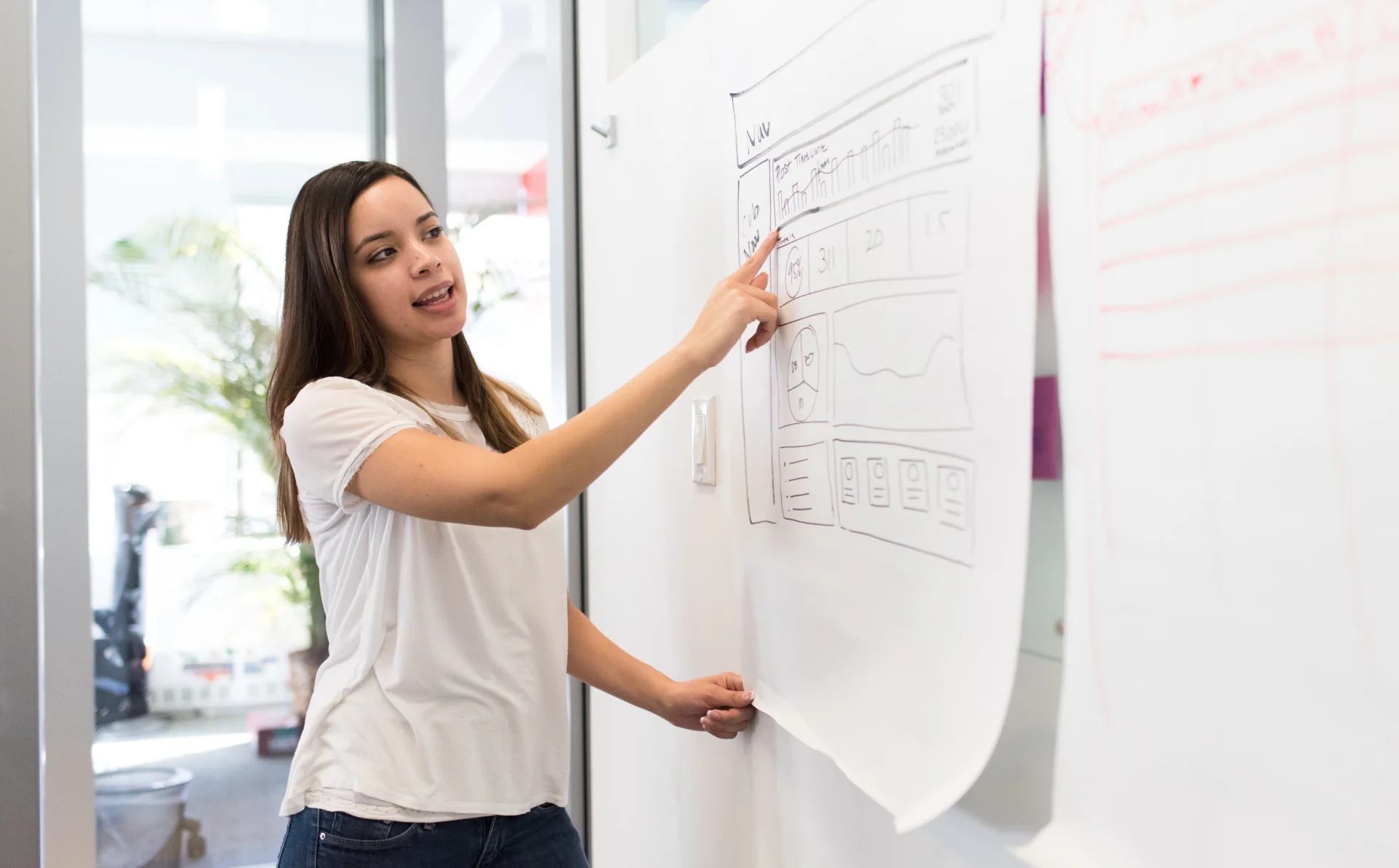 Young designer planning and ideating on a whiteboard surface