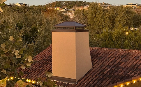 Custom metal chimney cap installed on a stucco chimney for improved protection and airflow.