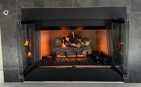 Modern gas fireplace with new gas log set, steel surround, and clean-burning flame.