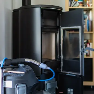 Fireplace cleaning using HEPA vacuum equipment to remove soot and debris