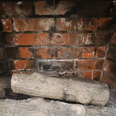 Close-up of firebox masonry showing damage requiring professional fireplace repair