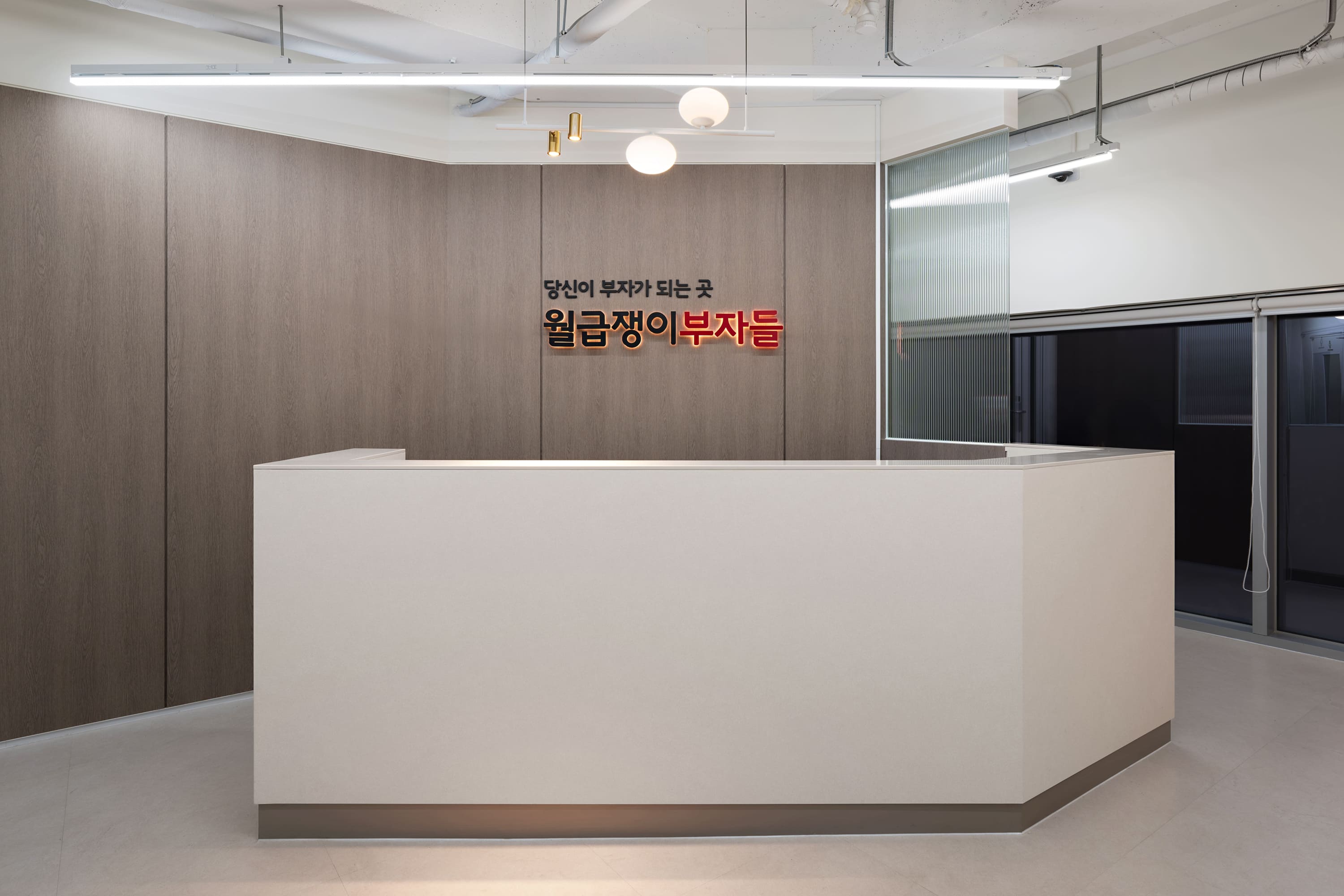 월급쟁이부자들 사옥 인테리어 – 브랜드 사이니지와 안내 데스크 정면
