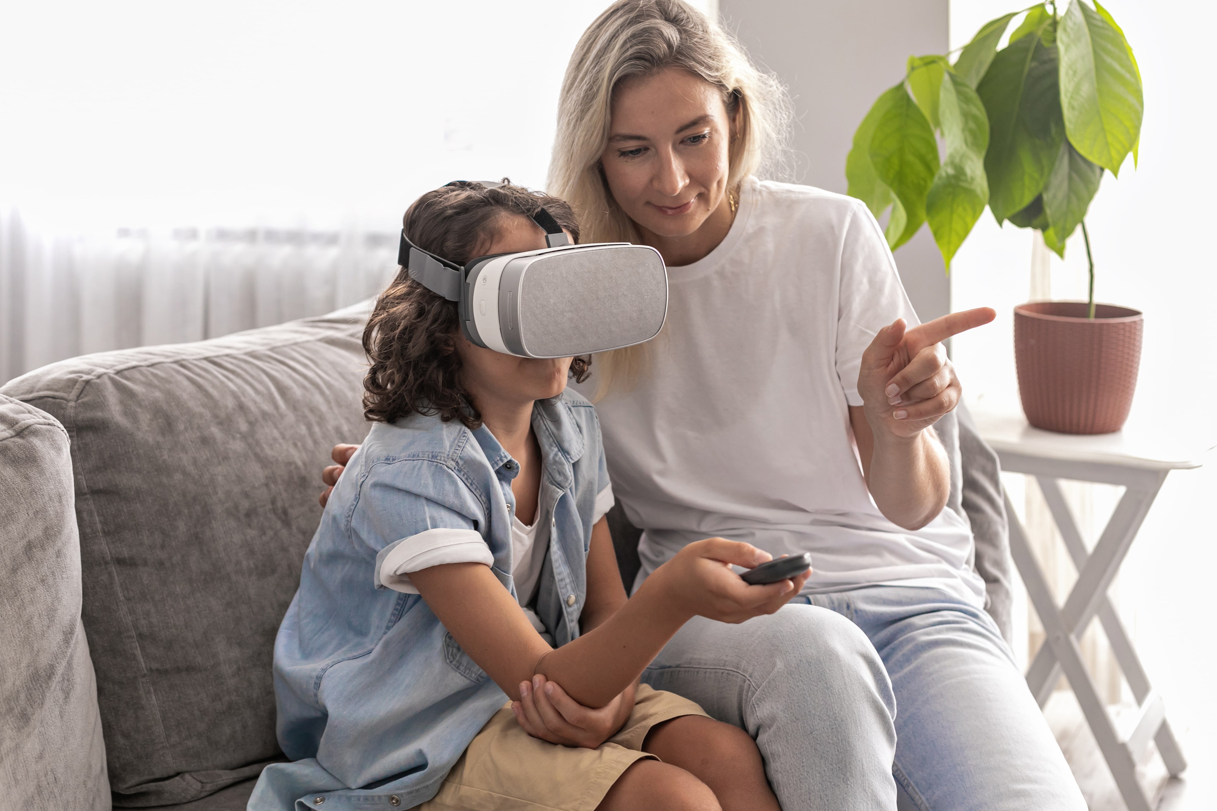 Chłopiec korzystający z gogli VR pod opieką rodzica. 