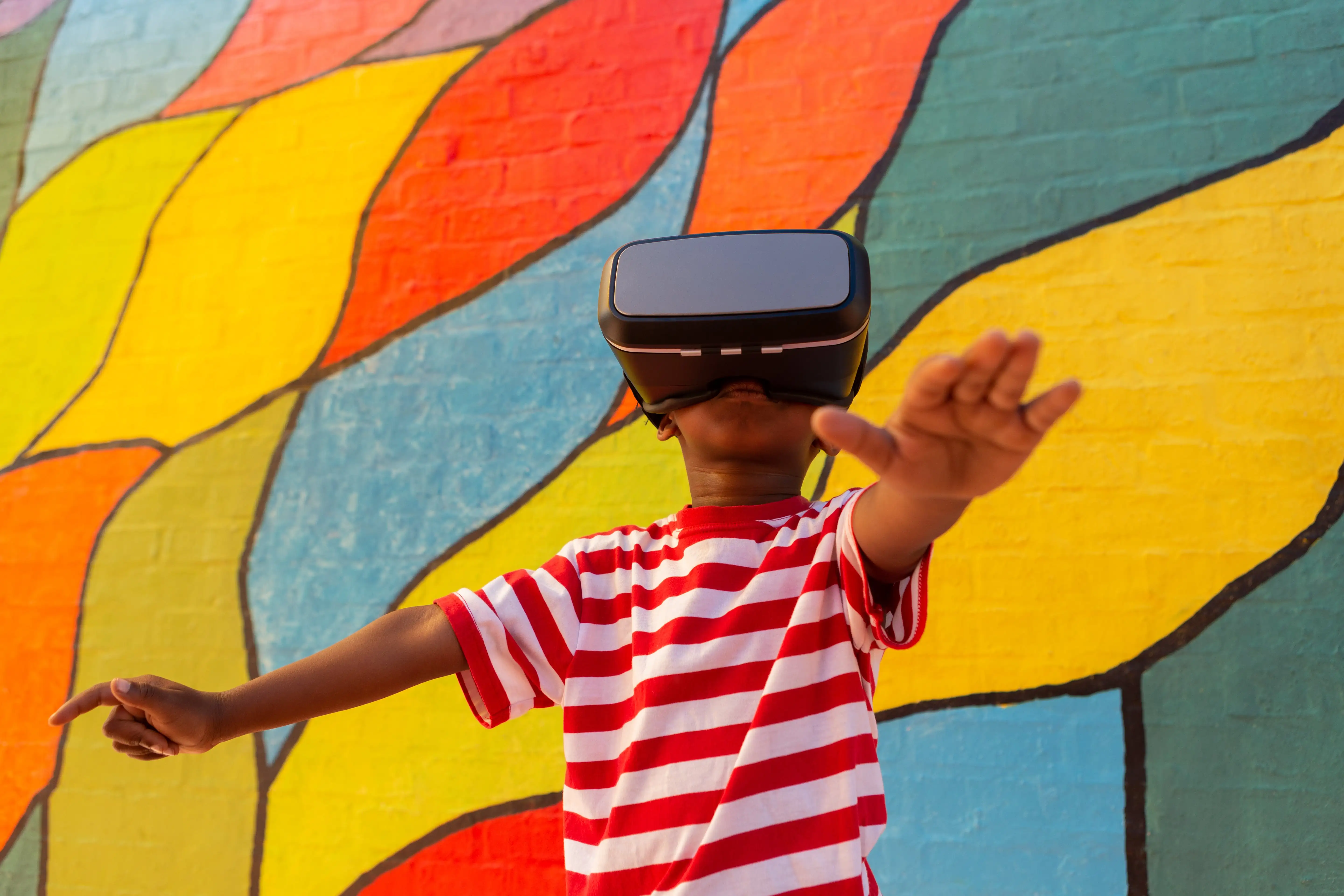 Dziecko w goglach VR podczas zajęć arteterapii, eksplorujące kolorowy wirtualny świat i rozwijające kreatywność poprzez sztukę w technologii immersyjnej.
