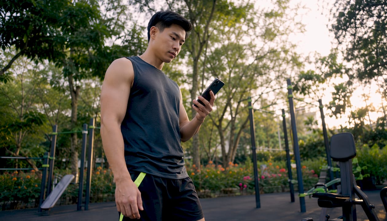 Man consulting workout app at gym