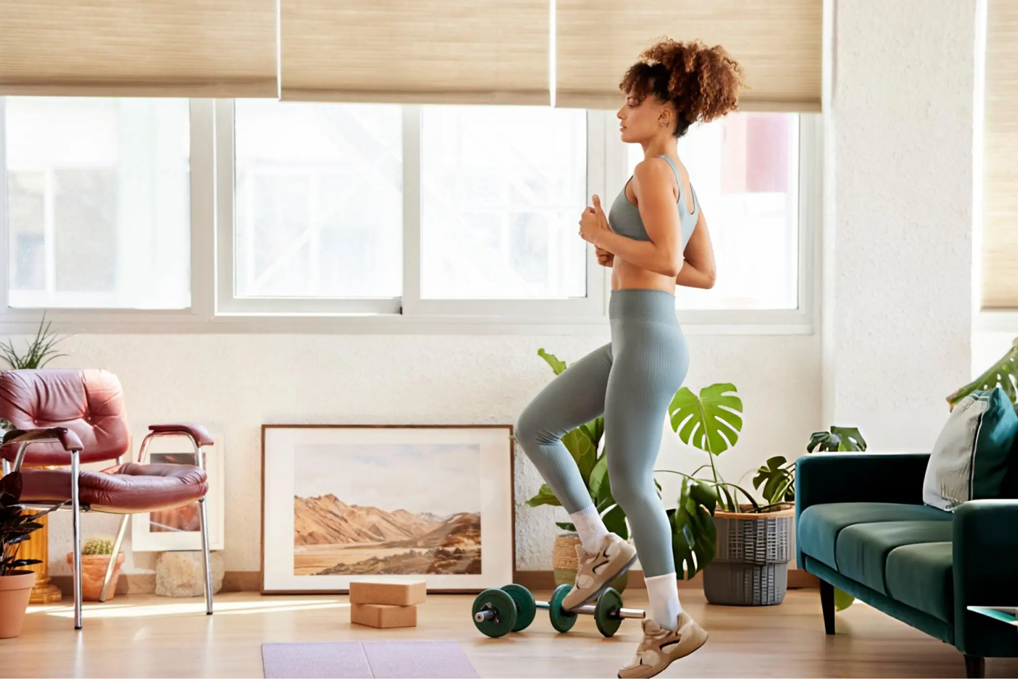 Woman in a bright living room exercises on a balance board, surrounded by plants, furniture, and sunlight, conveying wellness and energy.