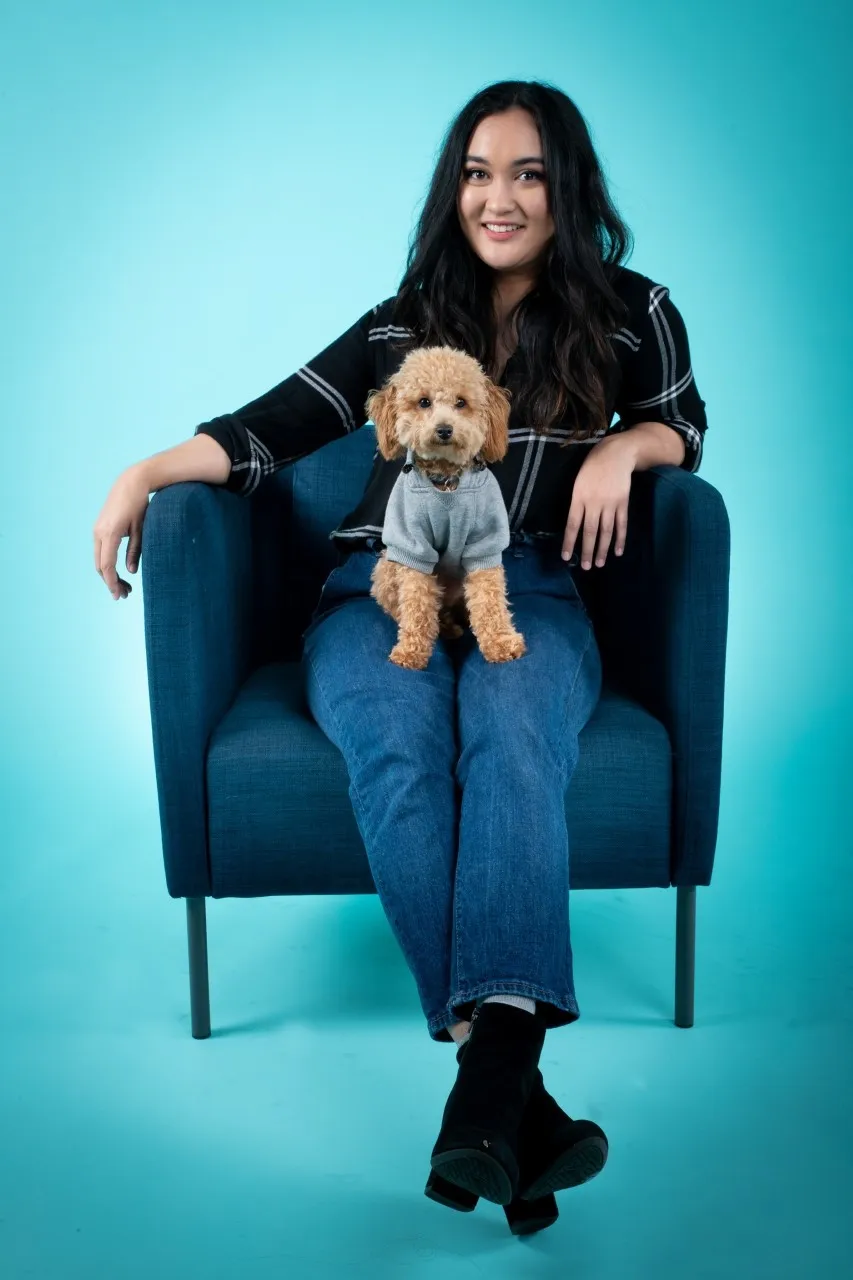 Former PY Intern Wylona Bouwens sits on a navy chair with her cute dog on her lap