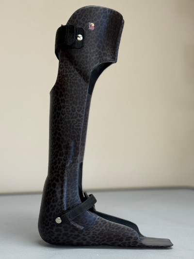 Black and gray leopard print ankle-foot orthosis brace with straps.