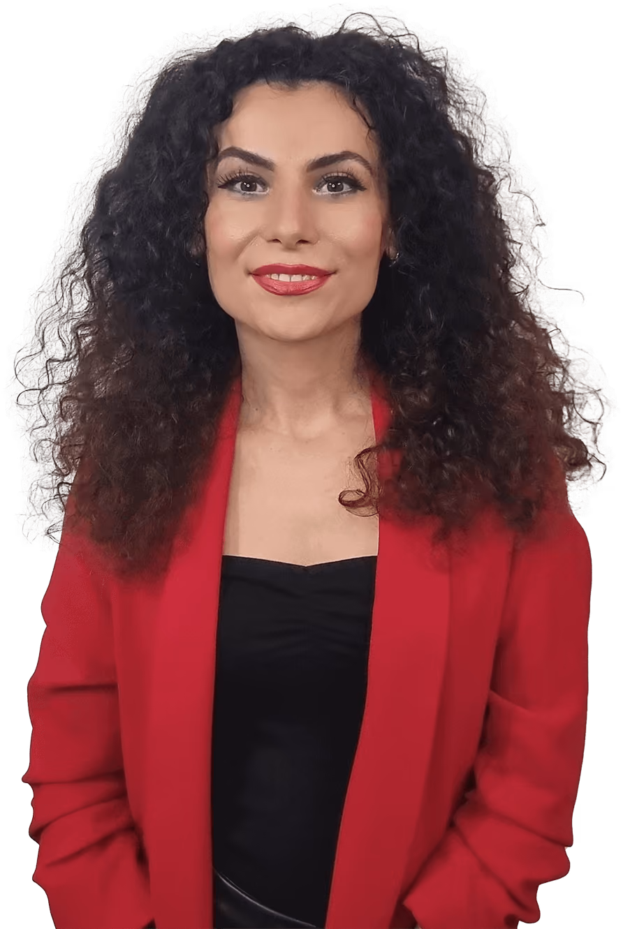 Femeie tânără cu păr creț purtând sacou roșu și top negru, zâmbind ușor.