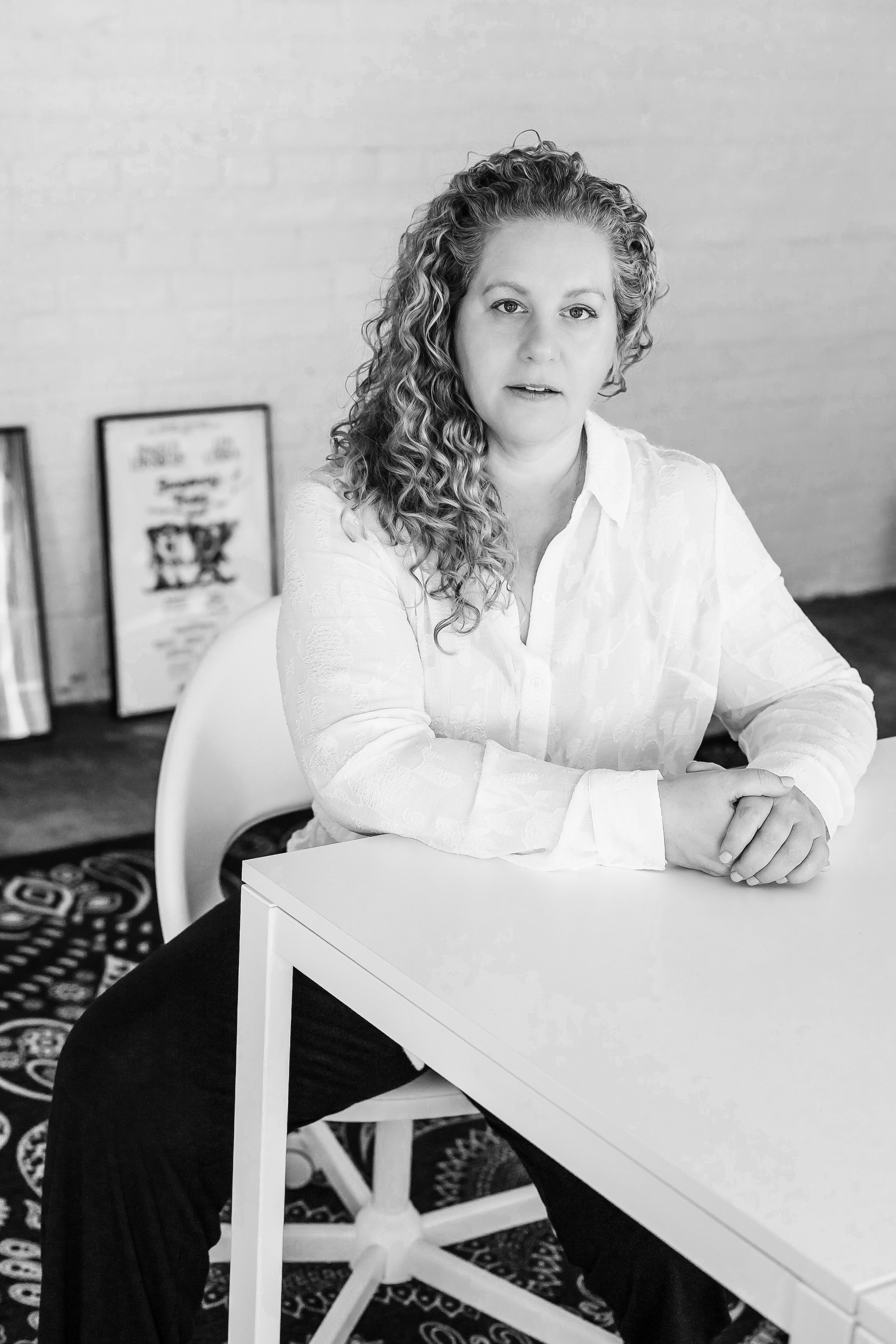 Jennie Jadow siting at a desk in a crisp, white, button down shirt