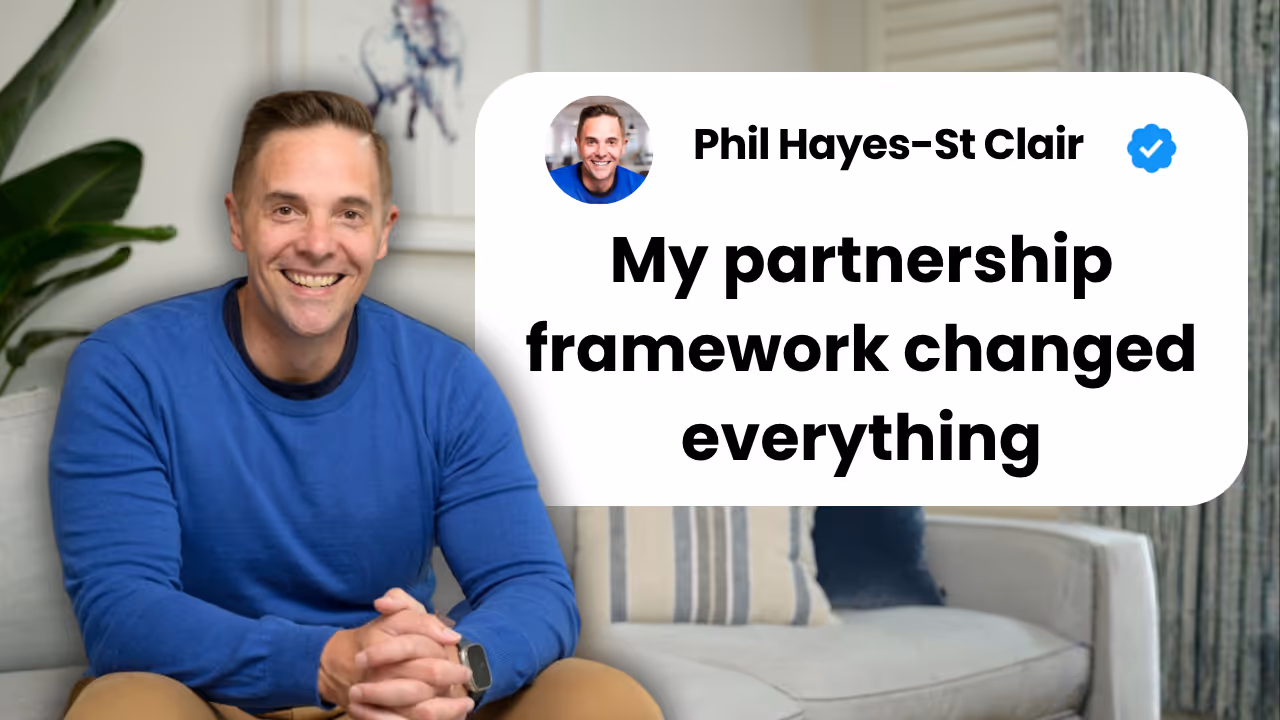 Phil Hayes-St Clair smiling at camera in blue sweater, sitting in modern office with white text bubble displaying "My partnership framework changed everything" next to his name and verification checkmark on white rounded rectangle background
