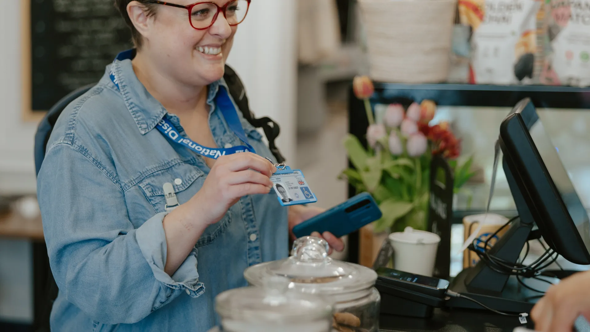 national disability card holder showing her card at a venue for carer ticket access