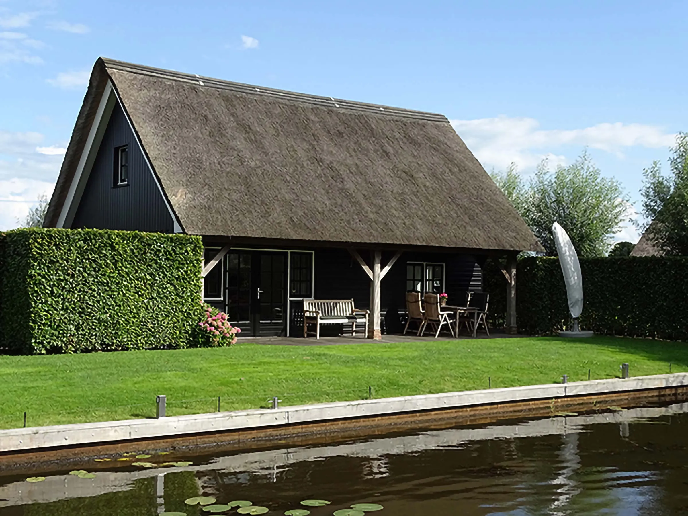 Rietgedekt vakantiehuis De Wielen met veranda en tuin aan het water in Wetering