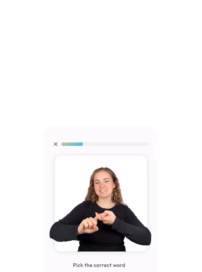 Woman in black shirt smiling and demonstrating a sign with both hands in front of a white background.