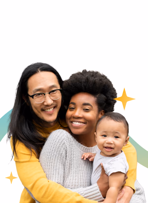 Smiling couple embracing while holding their baby, with decorative star shapes in the background.