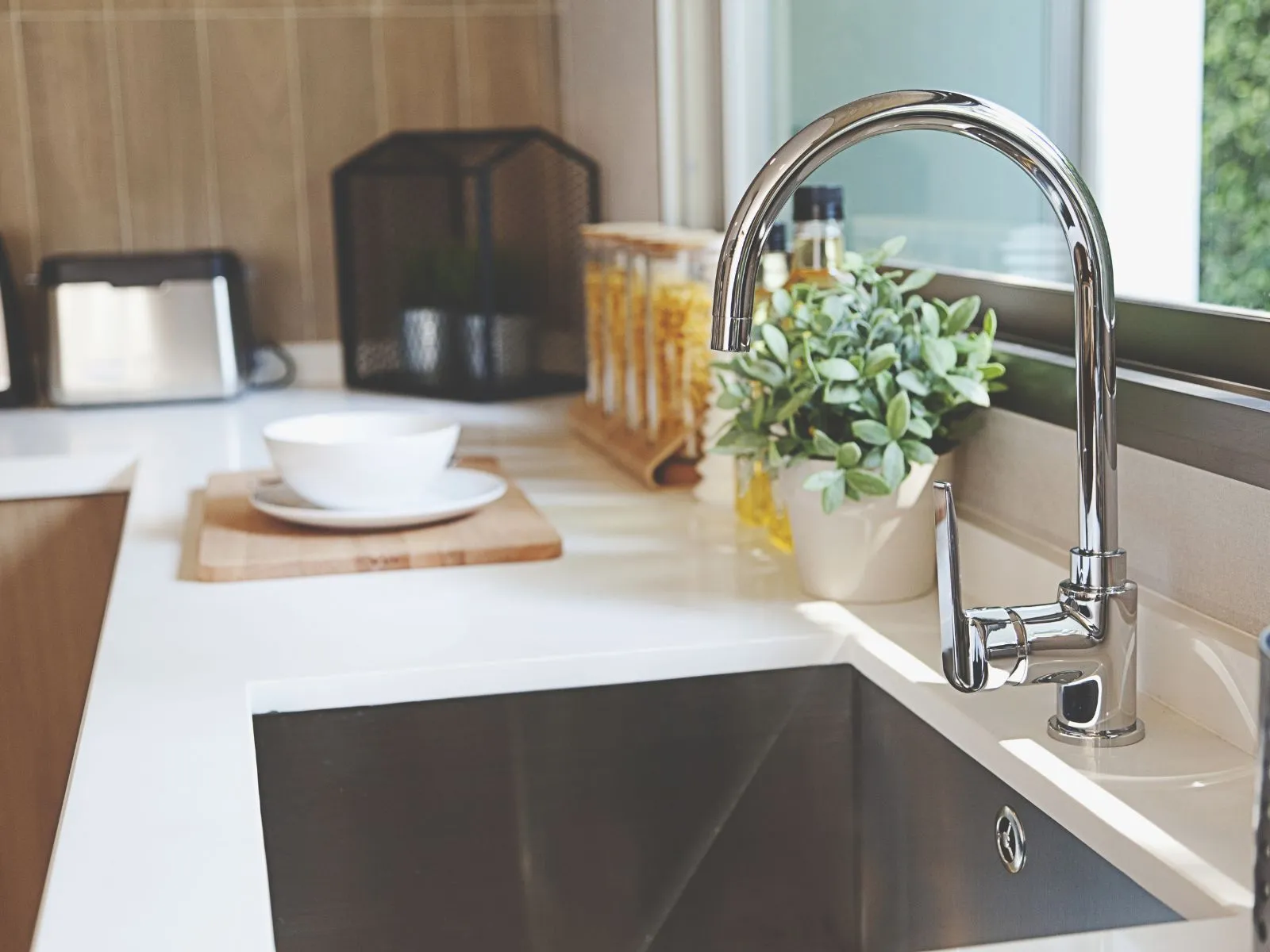 Modern kitchen sink setup highlighting replacement services for faucets and plumbing fixtures, ideal for addressing water heater problems, specific needs, and water heater needs with efficient tankless units and new water heater options to prevent issues and potential damage in homes.