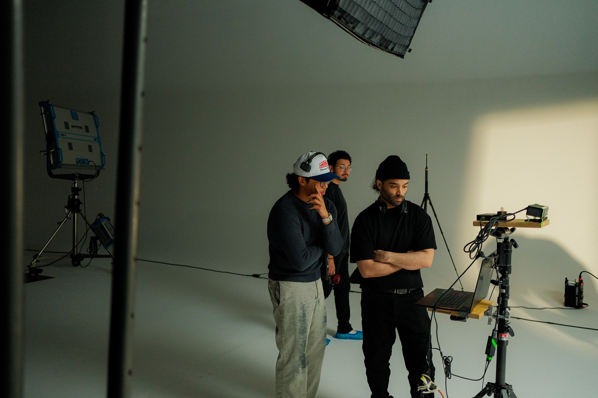 Director and crew reviewing footage on a laptop at the video village on the cyc set