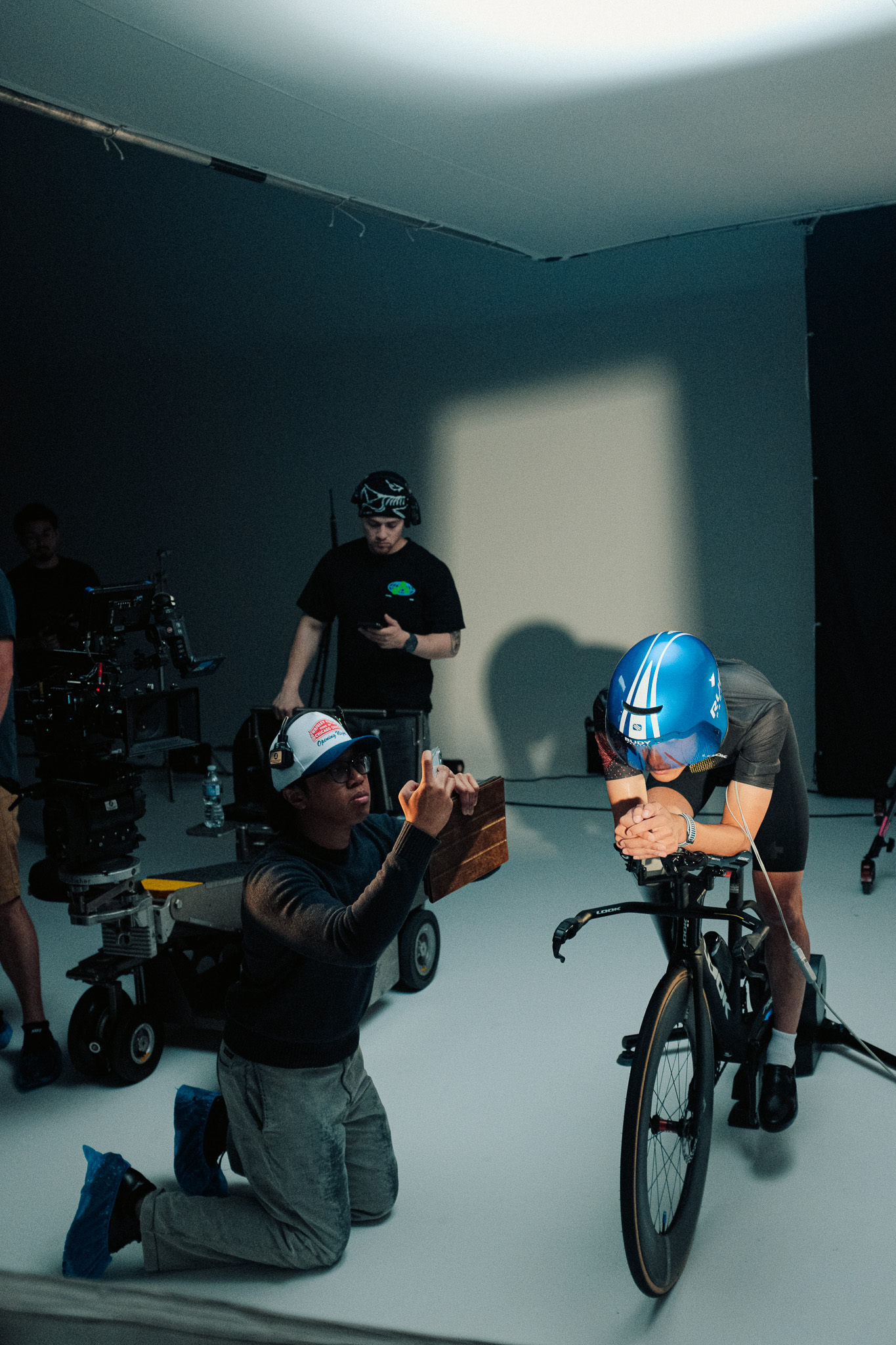 Director kneeling to show Kai a frame on his phone between takes