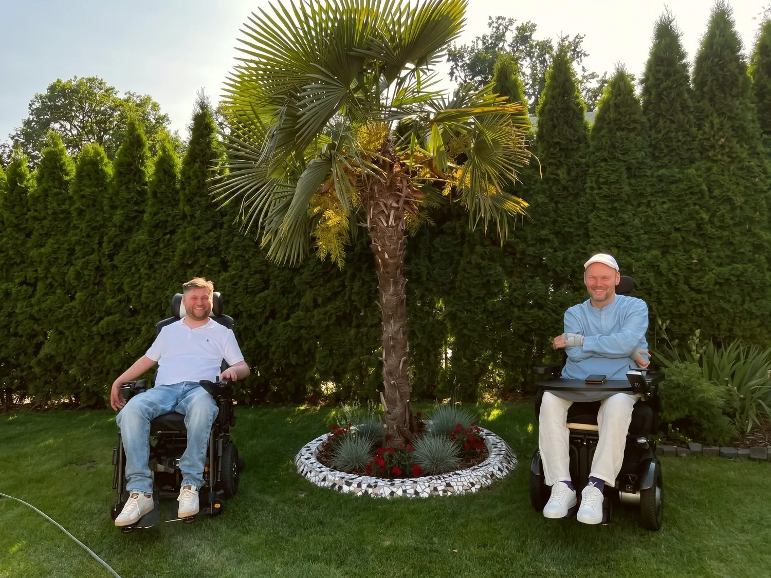 Paweł und Daniel im Rollstuhl unter einer Palme