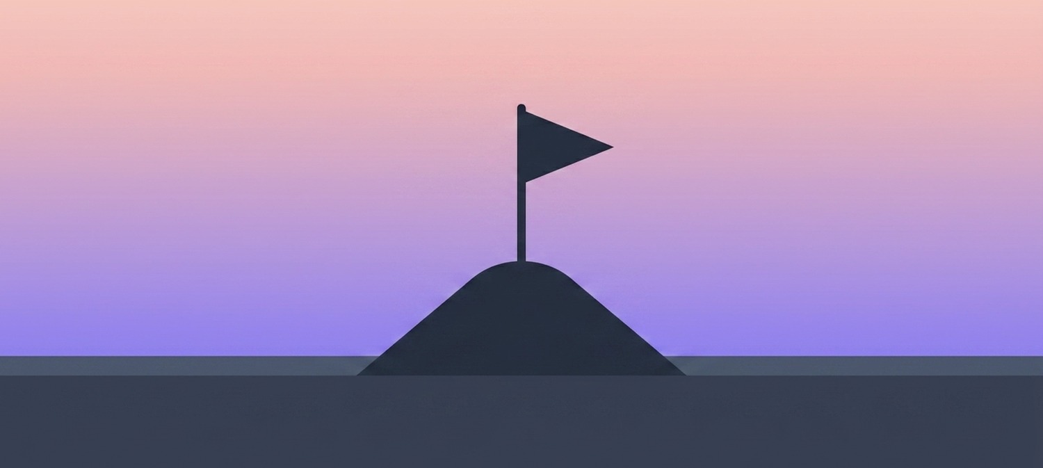A small flag planted on a miniature mountain summit