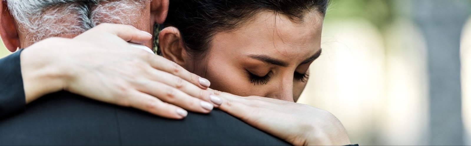 Close-up of a grieving woman embracing a loved one, symbolizing connection, mourning, and coping with grief and loss through compassionate Grief and Loss Therapy.
