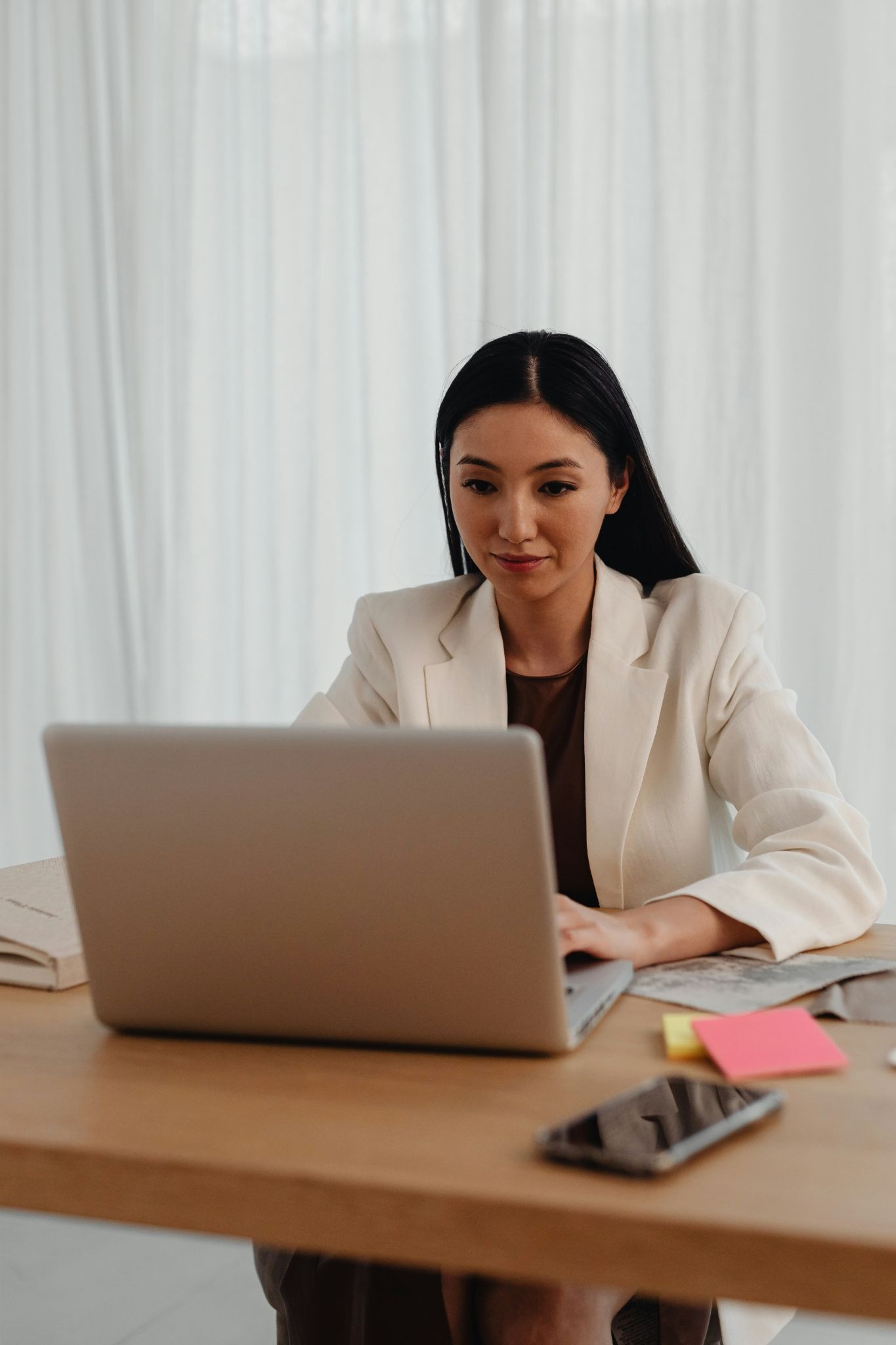Professional woman working under pressure, illustrating perfectionism, chronic stress, and the mind-body connection to chronic pain.