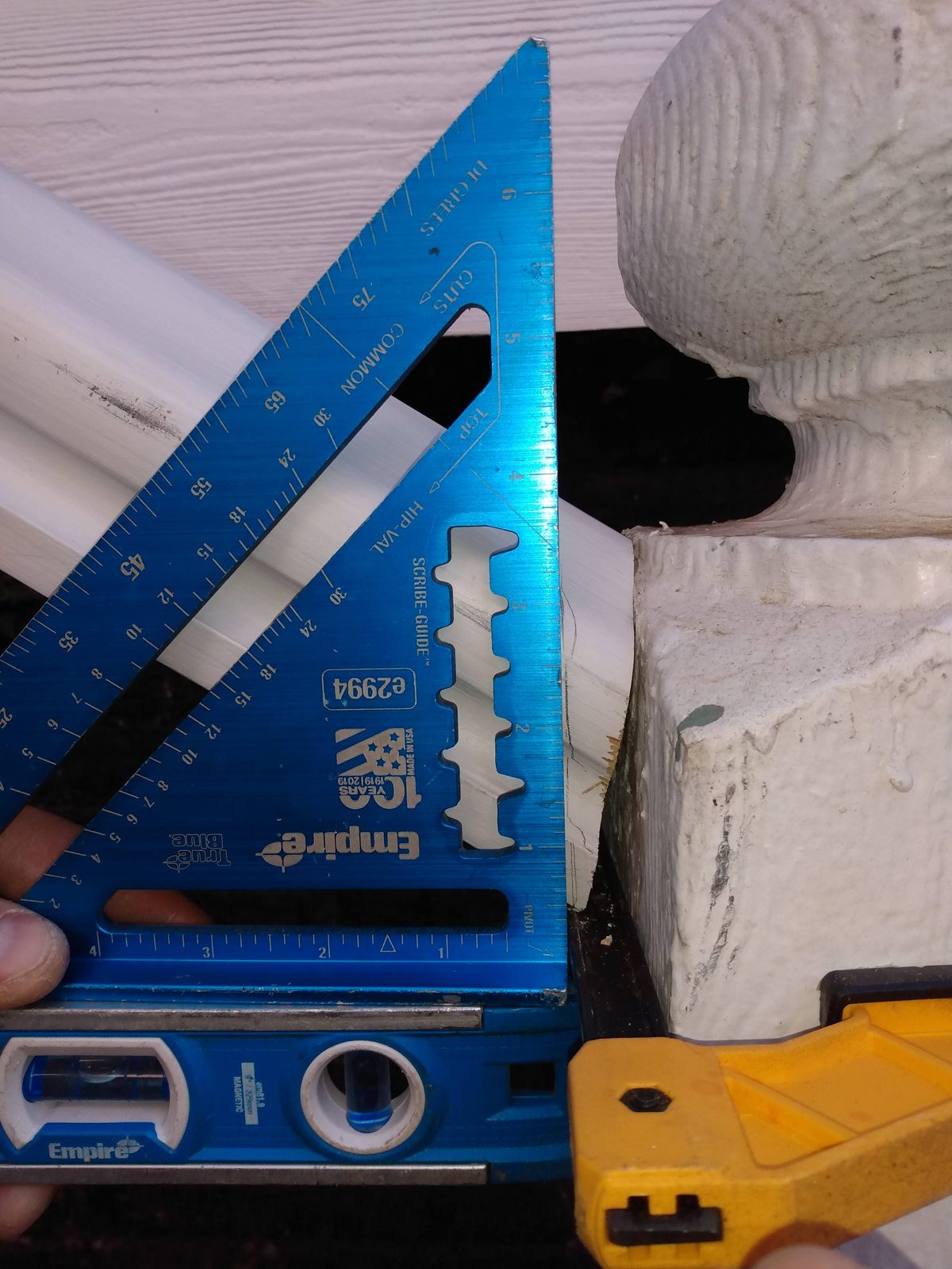 Checking a turned baluster against a speed square during porch rebuild