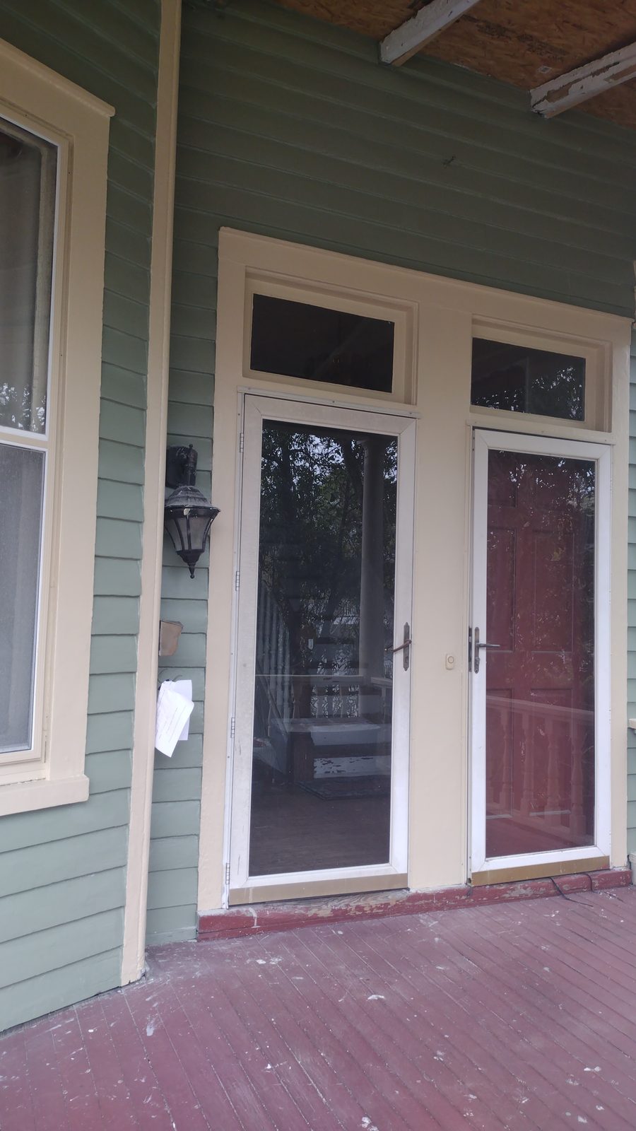 Victorian front porch with white-trimmed double doors and freshly painted clapboard siding