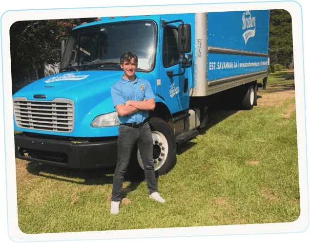 BC Brothers Moving team member standing beside branded truck for long-distance relocation