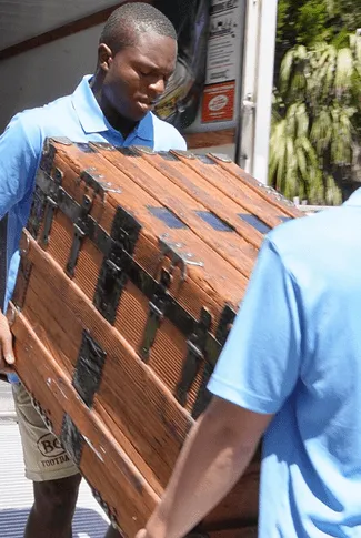 BC Brothers Moving team loading wooden furniture into a truck