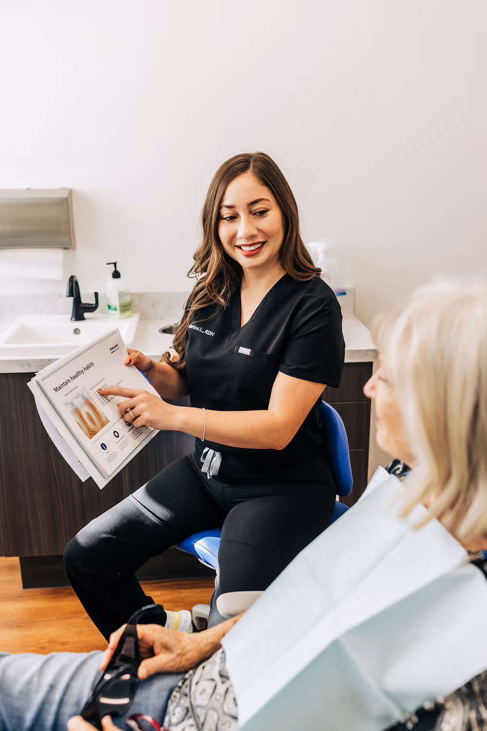 A woman sitting in a chair reading a paper.