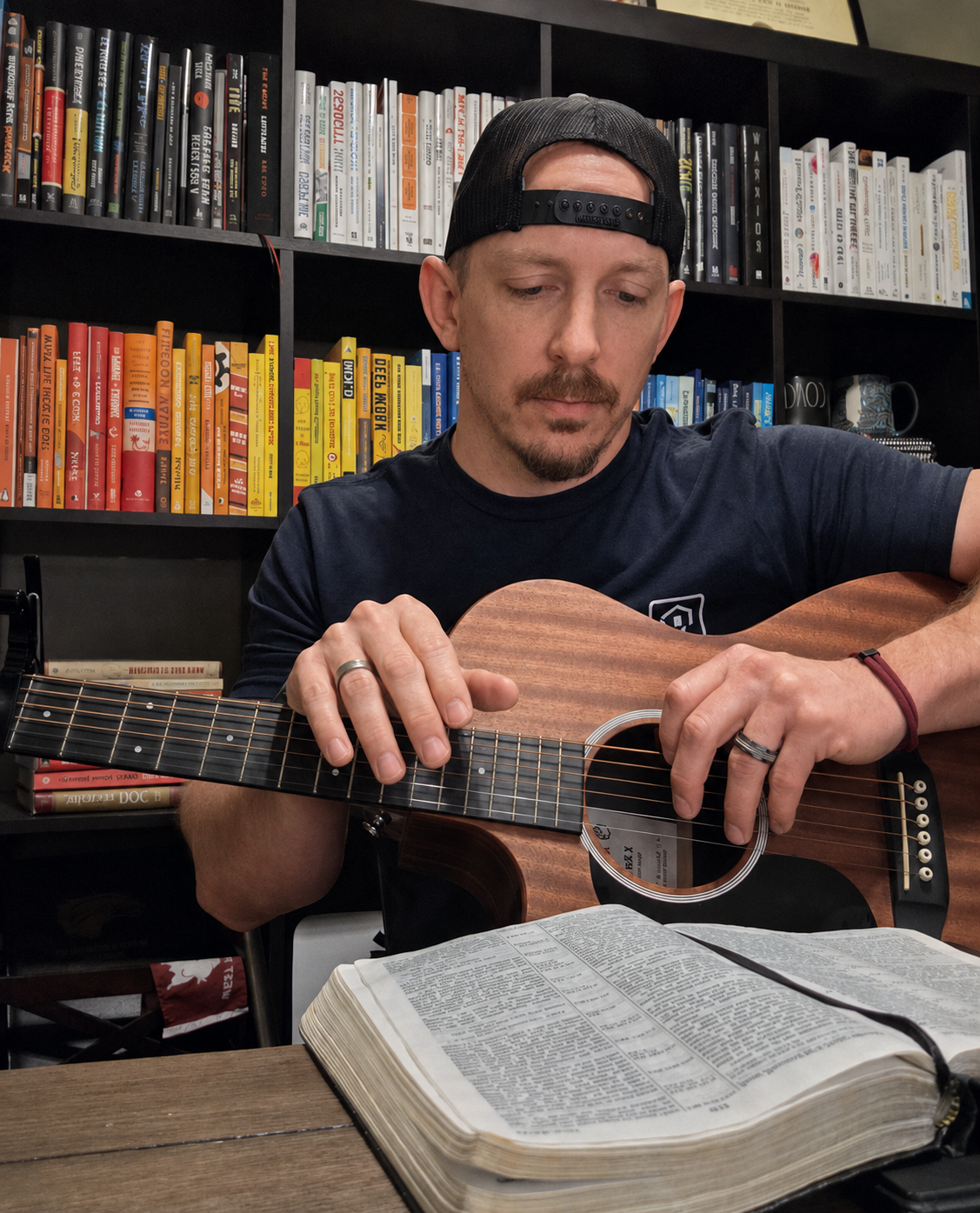 Mark playing a guitar during a devotional