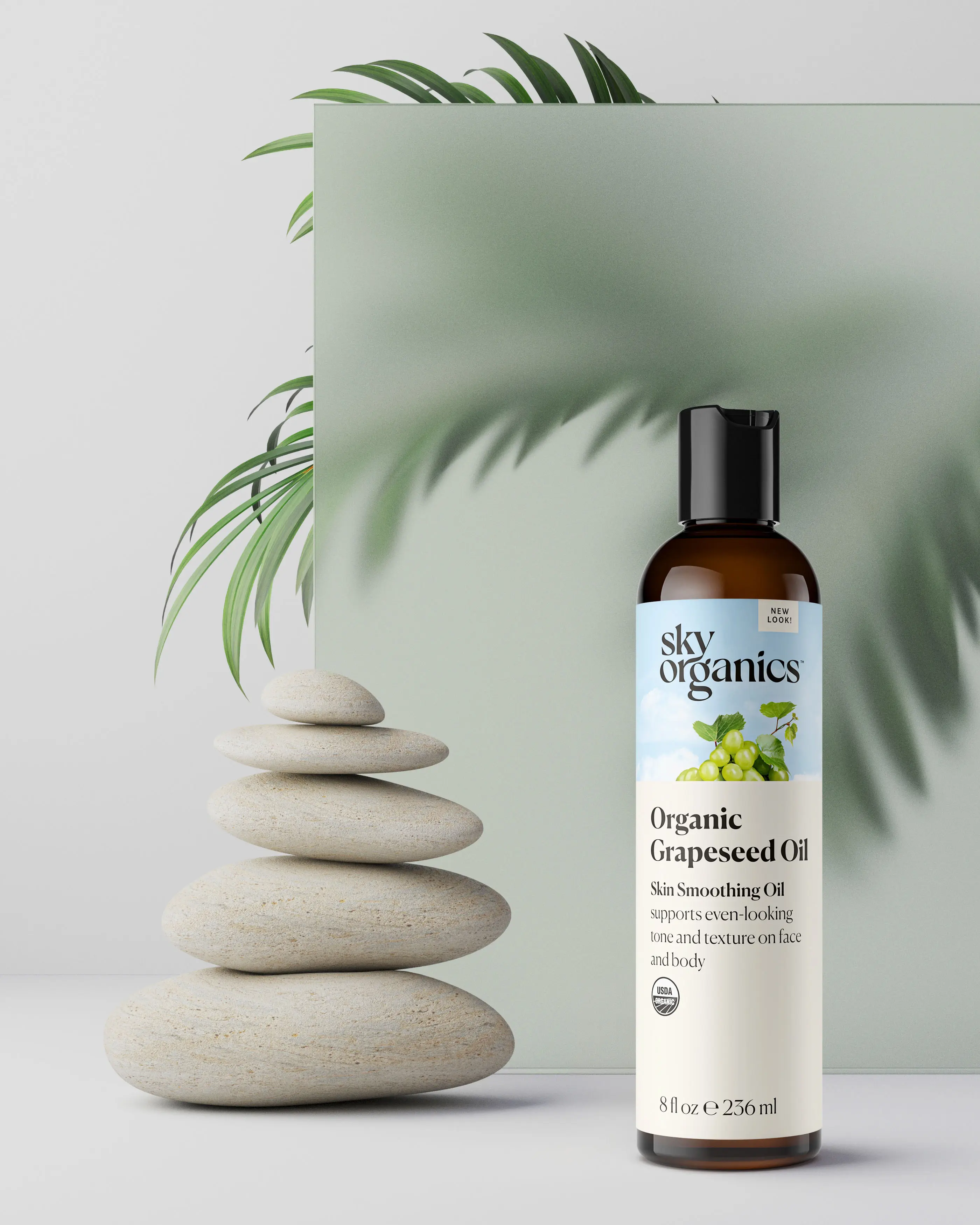 3D product rendering of Sky Organics Grapeseed Oil bottle in a spa-inspired scene with balancing stones and palm leaf shadows