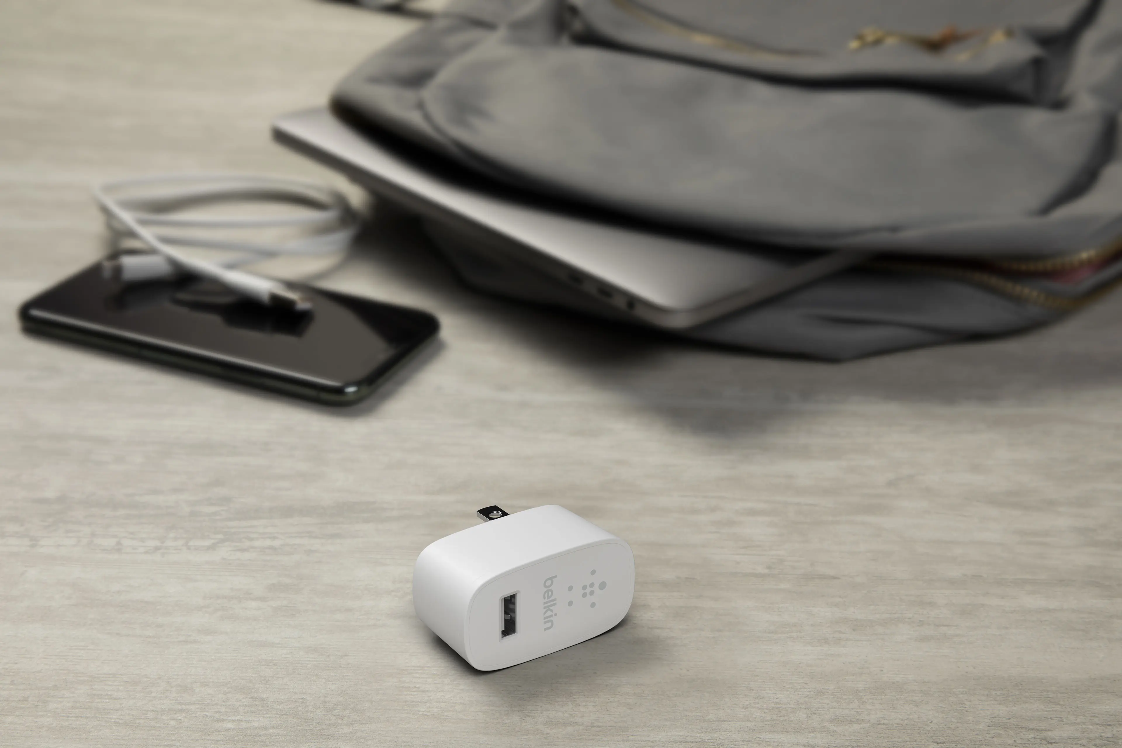 3D product visualization of Belkin USB wall charger with travel accessories on desk