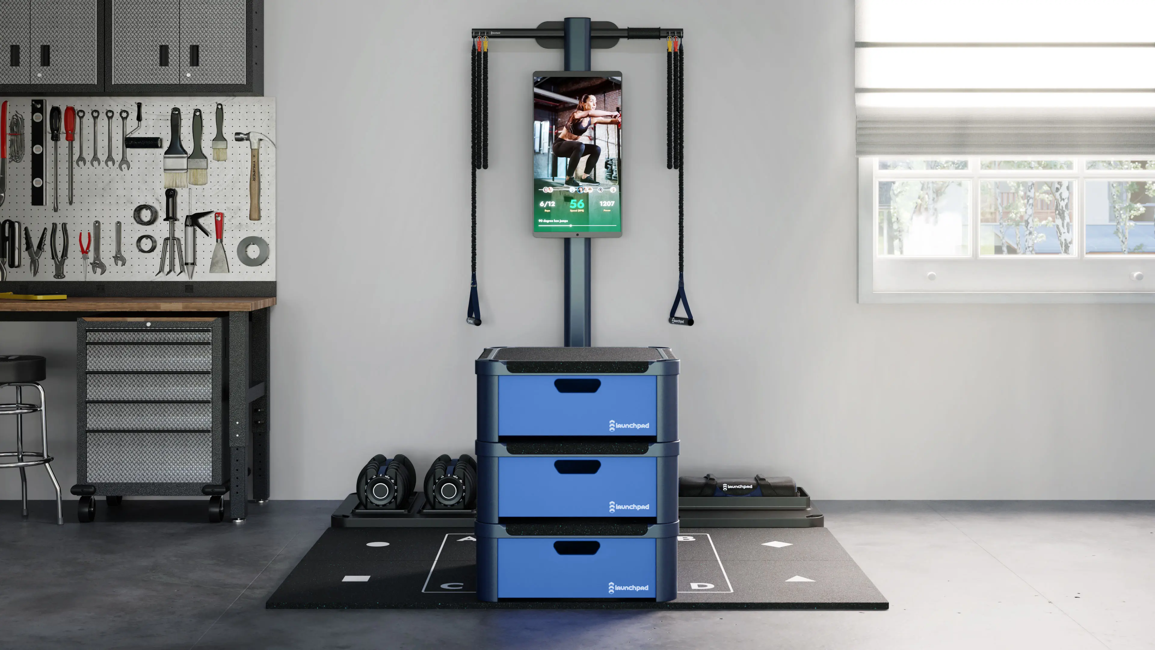 3D lifestyle visualization of Launchpad fitness platform set up in a garage gym with resistance bands, dumbbells, and interactive training display
