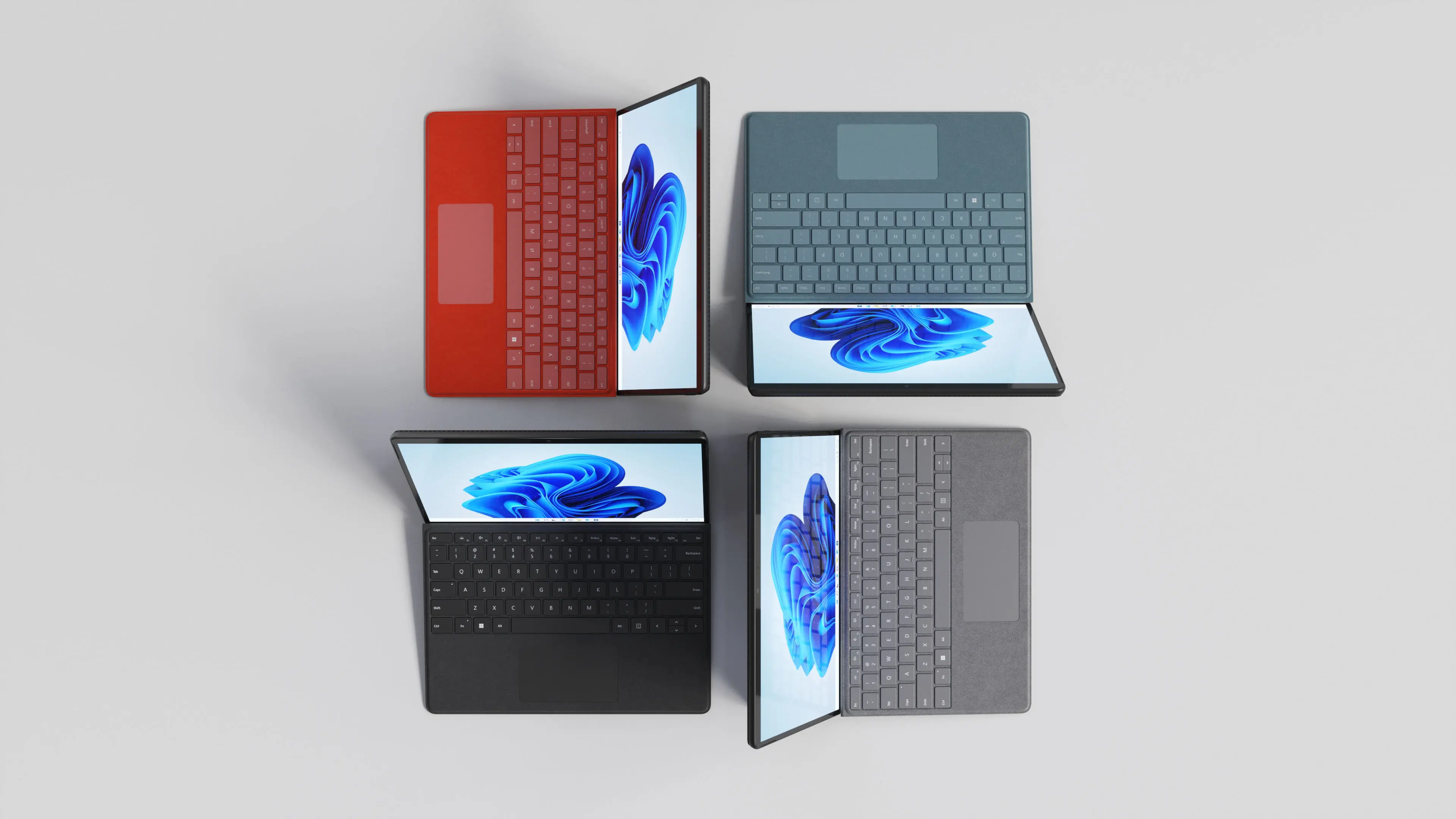 Top-down 3D product rendering of four Microsoft Surface Pro 8 devices in different keyboard colors, emphasizing versatility and modern design.