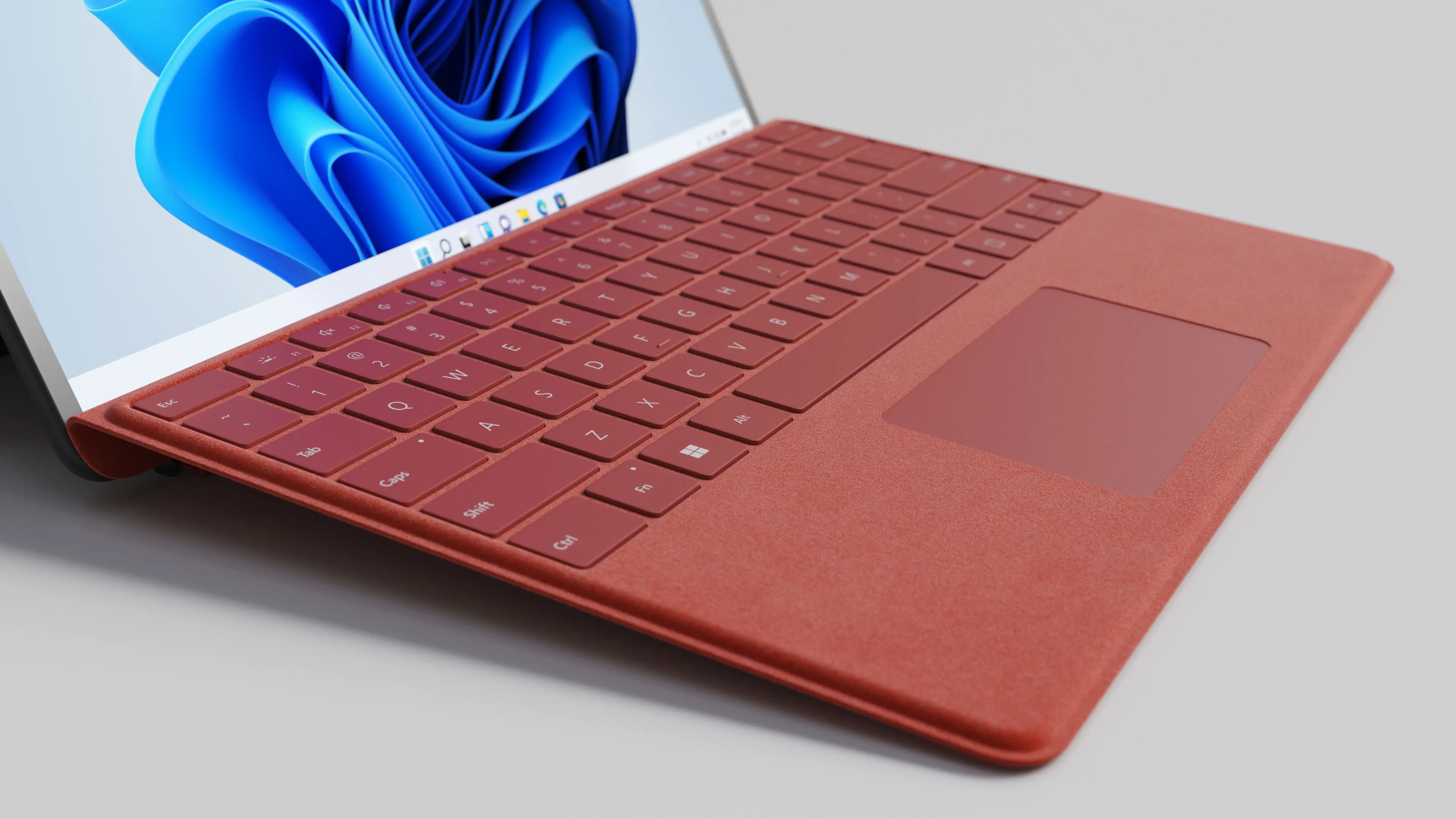 Close-up 3D rendering of a red Surface Pro keyboard and touchpad connected to a tablet.